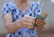 Mulher de idade contando dinheiro.